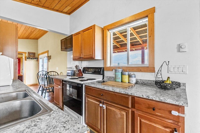 2571 Airport Rd, Eureka, MT 59917 - kitchen with electric range, wooden ceiling, light countertops, brown cabinets, and wood finished floors