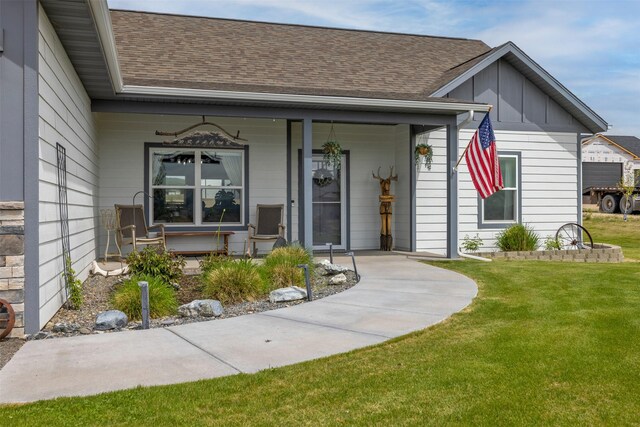 2320 Kenai Rd, Helena, MT 59602 - view of exterior entry with board and batten siding, covered porch, a shingled roof, and a lawn