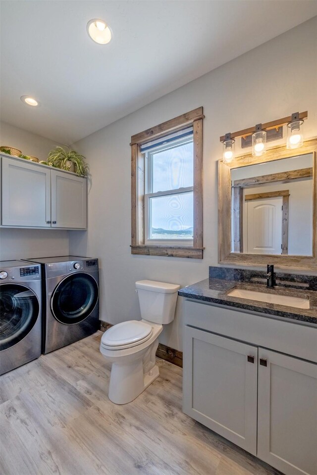 2320 Kenai Rd, Helena, MT 59602 - bathroom with washing machine and clothes dryer, wood finished floors, vanity, toilet, and baseboards