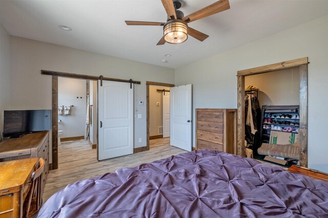 2320 Kenai Rd, Helena, MT 59602 - bedroom with light wood-style flooring, a closet, a spacious closet, a barn door, and a ceiling fan