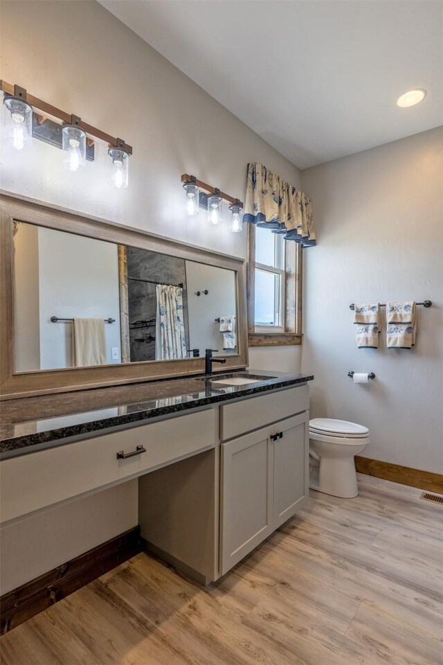 2320 Kenai Rd, Helena, MT 59602 - bathroom with wood finished floors, toilet, a tile shower, and vanity