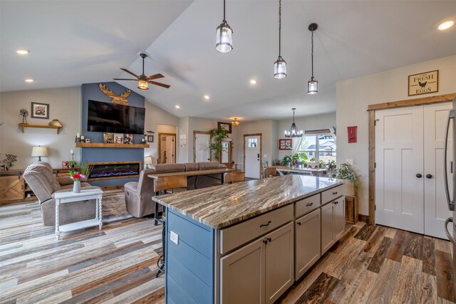 2320 Kenai Rd, Helena, MT 59602 - kitchen with a fireplace, vaulted ceiling, ceiling fan, a center island, and open floor plan