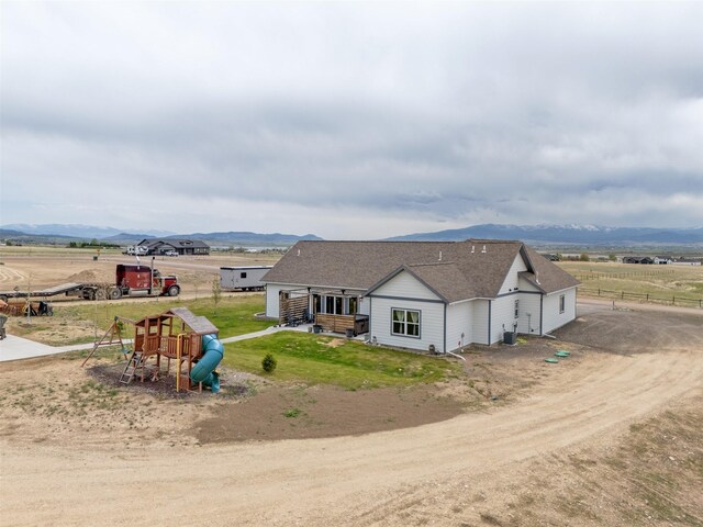 2320 Kenai Rd, Helena, MT 59602 - view of front facade featuring a playground, a rural view, a mountain view, roof with shingles, and cooling unit