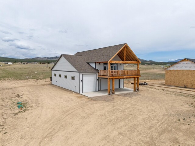 2320 Kenai Rd, Helena, MT 59602 - view of front of home featuring driveway, a deck, a shingled roof, and a garage