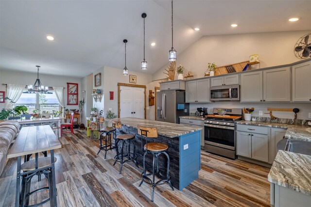 2320 Kenai Rd, Helena, MT 59602 - kitchen featuring stainless steel appliances, gray cabinets, a breakfast bar area, wood finished floors, and a center island