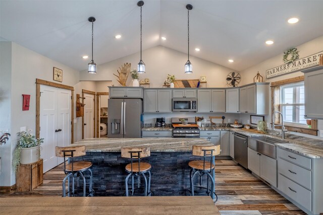 2320 Kenai Rd, Helena, MT 59602 - kitchen with appliances with stainless steel finishes, gray cabinetry, a breakfast bar area, light stone counters, and a sink