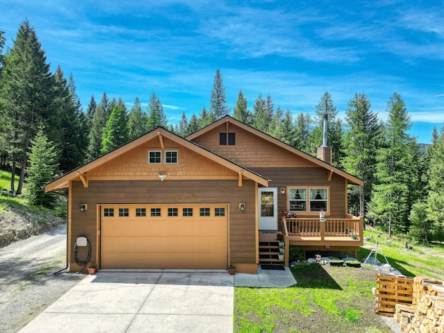 598 Tamarack Ln, Rexford, MT 59930 - rustic home featuring driveway, an attached garage, a deck, and a view of trees