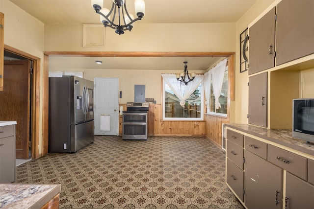 505 Oak St, Anaconda, MT 59711 - kitchen featuring appliances with stainless steel finishes, a chandelier, wooden walls, light countertops, and baseboards