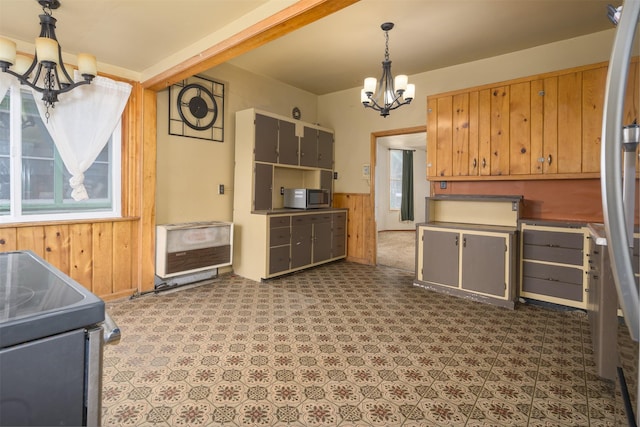 505 Oak St, Anaconda, MT 59711 - kitchen featuring a chandelier, appliances with stainless steel finishes, wood walls, heating unit, and a wainscoted wall