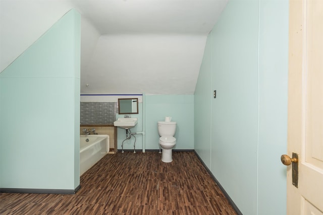 505 Oak St, Anaconda, MT 59711 - bathroom featuring wood finished floors, a garden tub, toilet, vaulted ceiling, and a sink