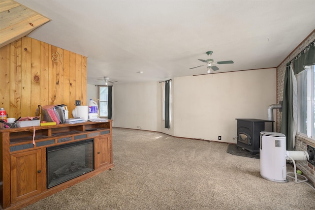 505 Oak St, Anaconda, MT 59711 - living area featuring a wood stove, a ceiling fan, and light colored carpet