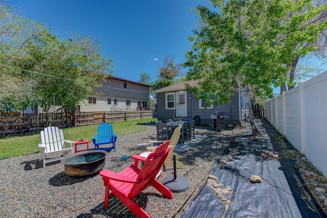 1202 Walnut St, Helena, MT 59601 - fenced backyard featuring a fire pit, a patio area, and an outdoor structure
