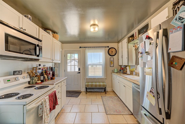 1202 Walnut St, Helena, MT 59601 - kitchen with appliances with stainless steel finishes, a sink, light countertops, light tile patterned floors, and white cabinetry