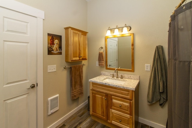 111 Lupfer Loop Rd, Olney, MT 59927 - full bath with heating unit, vanity, wood finished floors, and baseboards