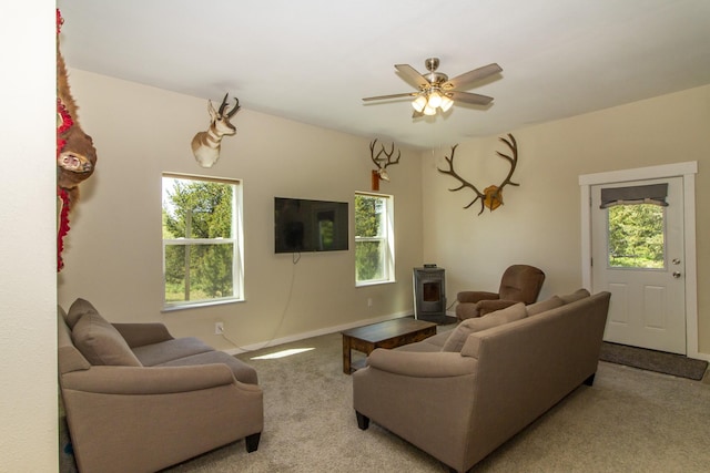 111 Lupfer Loop Rd, Olney, MT 59927 - carpeted living room with a wood stove, healthy amount of natural light, a ceiling fan, and baseboards