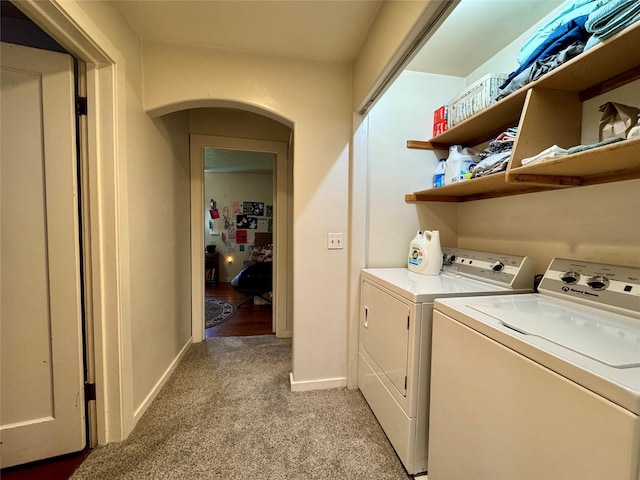 172 Garden Rd, Libby, MT 59923 - laundry room with washing machine and dryer, light carpet, baseboards, and arched walkways