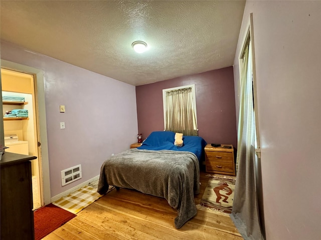 172 Garden Rd, Libby, MT 59923 - bedroom featuring light wood finished floors, a textured ceiling, heating unit, and baseboards