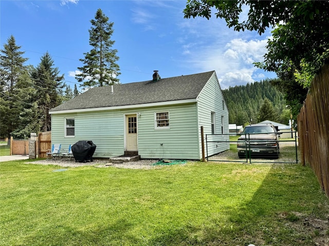 172 Garden Rd, Libby, MT 59923 - rear view of property featuring a gate, a shingled roof, entry steps, and a chimney
