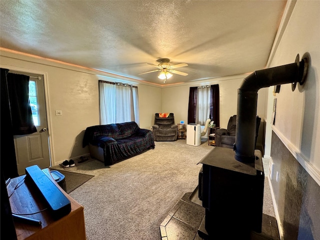 172 Garden Rd, Libby, MT 59923 - carpeted living area with a textured ceiling, a wood stove, ceiling fan, and ornamental molding
