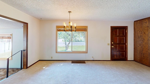 906 11th St E, Polson, MT 59860 - unfurnished dining area with a chandelier, a textured ceiling, carpet flooring, and baseboards