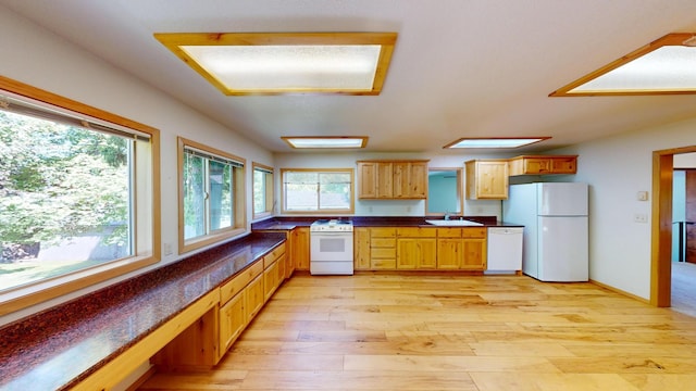 906 11th St E, Polson, MT 59860 - kitchen featuring white appliances, dark countertops, a sink, and light wood-type flooring