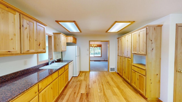 906 11th St E, Polson, MT 59860 - kitchen featuring a sink, white appliances, light wood-type flooring, light brown cabinetry, and baseboards
