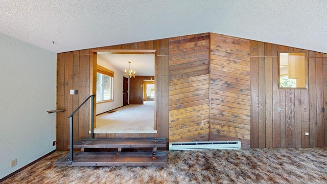 906 11th St E, Polson, MT 59860 - interior space with lofted ceiling, wooden walls, a chandelier, a textured ceiling, and baseboard heating
