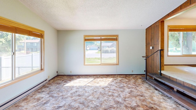 906 11th St E, Polson, MT 59860 - unfurnished living room featuring a baseboard radiator, a textured ceiling, and carpet flooring