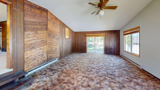906 11th St E, Polson, MT 59860 - carpeted spare room featuring lofted ceiling, baseboard heating, wood walls, and a ceiling fan