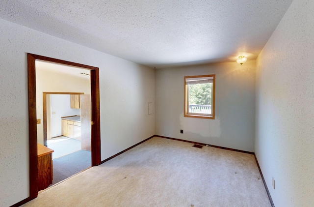 906 11th St E, Polson, MT 59860 - empty room featuring carpet, a textured ceiling, a textured wall, and baseboards