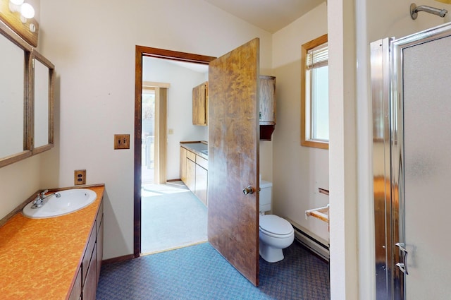 906 11th St E, Polson, MT 59860 - bathroom with vanity, baseboard heating, toilet, and a shower with shower door