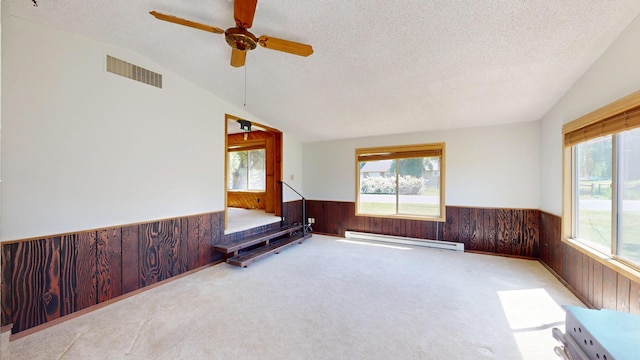 906 11th St E, Polson, MT 59860 - sitting room featuring wainscoting, wooden walls, baseboard heating, lofted ceiling, and carpet flooring