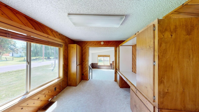 906 11th St E, Polson, MT 59860 - corridor with a textured ceiling, light carpet, and wooden walls