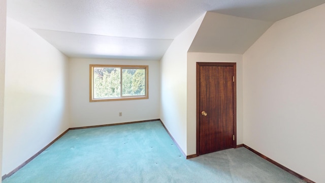 906 11th St E, Polson, MT 59860 - unfurnished bedroom featuring light carpet, baseboards, vaulted ceiling, and a closet