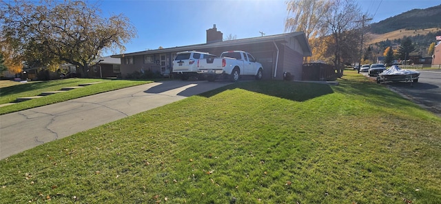1125 Choteau St, Helena, MT 59601 - view of front facade featuring a chimney, a front lawn, and driveway