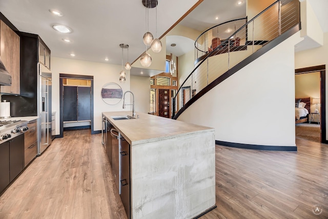 162 Jackson Creek Rd, Montana City, MT 59634 - kitchen with a sink, light countertops, light wood-style flooring, stainless steel appliances, and a center island with sink
