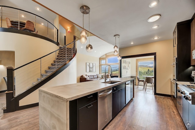 162 Jackson Creek Rd, Montana City, MT 59634 - kitchen with appliances with stainless steel finishes, a sink, a center island with sink, light wood-type flooring, and dark cabinets
