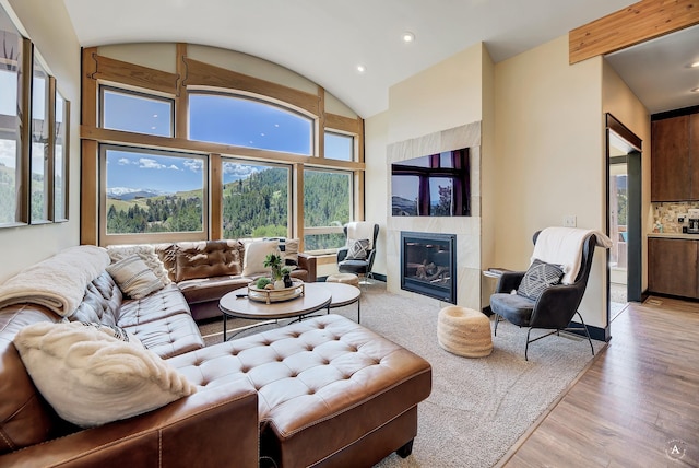 162 Jackson Creek Rd, Montana City, MT 59634 - living room with light wood-style floors, a tile fireplace, vaulted ceiling, and recessed lighting