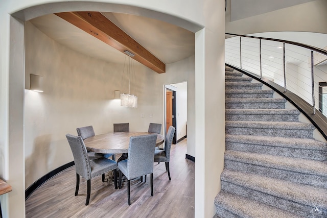 162 Jackson Creek Rd, Montana City, MT 59634 - dining space featuring wood finished floors, arched walkways, beamed ceiling, stairs, and baseboards