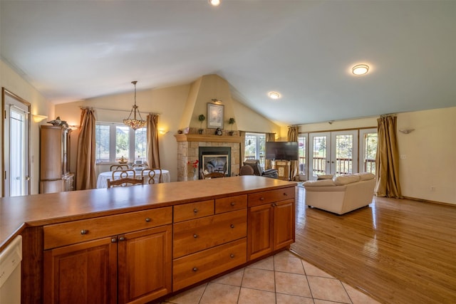 7551 York Rd, Helena, MT 59602 - kitchen with lofted ceiling, a fireplace, brown cabinetry, open floor plan, and dishwasher