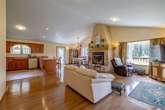 7551 York Rd, Helena, MT 59602 - living area with vaulted ceiling, light wood-type flooring, a fireplace, and a chandelier