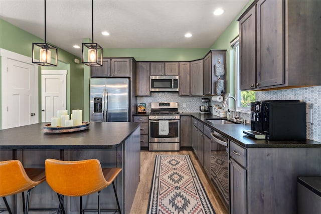 380 Stonybrook Dr, Missoula, MT 59804 - kitchen featuring stainless steel appliances, a sink, dark countertops, dark brown cabinetry, and recessed lighting