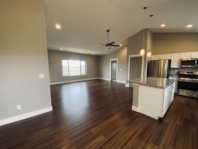 3883 Lovegrass Ln, Helena, MT 59602 - kitchen with appliances with stainless steel finishes, a center island, a ceiling fan, dark stone counters, and white cabinets