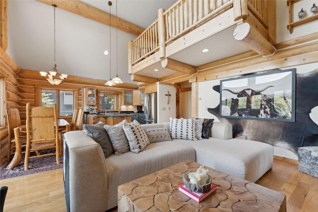 970 Colorado Ave, Whitefish, MT 59937 - living room with log walls, a chandelier, light wood-type flooring, beam ceiling, and a high ceiling