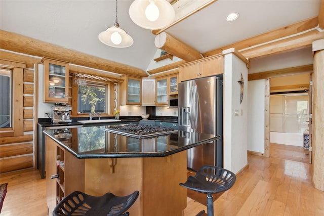 970 Colorado Ave, Whitefish, MT 59937 - kitchen with appliances with stainless steel finishes, a sink, light wood-type flooring, a breakfast bar, and a kitchen island