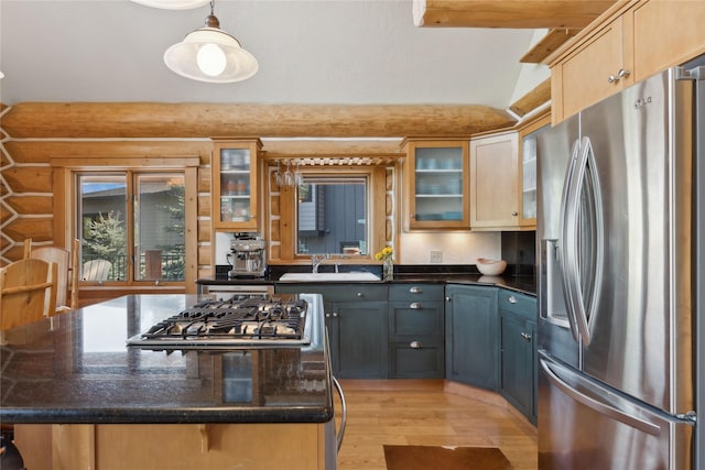 970 Colorado Ave, Whitefish, MT 59937 - kitchen featuring appliances with stainless steel finishes, a sink, light wood finished floors, a kitchen island, and glass insert cabinets