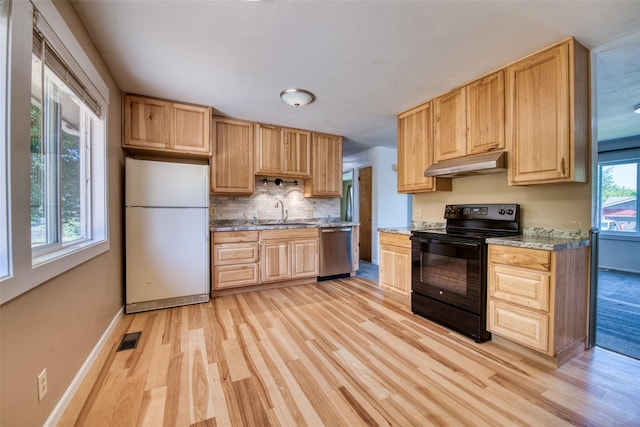 229 Glacier Dr, Lolo, MT 59847 - kitchen with freestanding refrigerator, black electric range, under cabinet range hood, dishwasher, and light wood-style floors