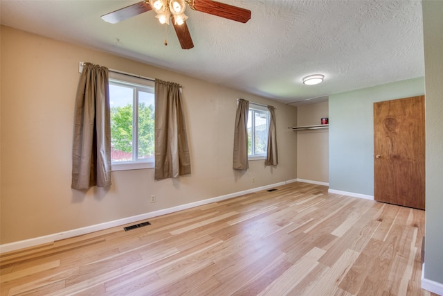 229 Glacier Dr, Lolo, MT 59847 - unfurnished bedroom with wood finished floors, baseboards, a textured ceiling, and ceiling fan
