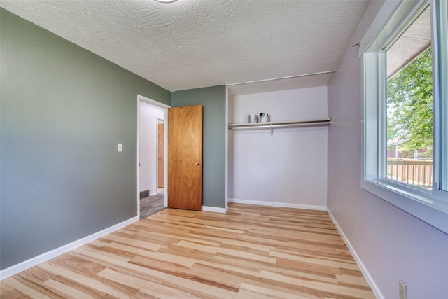 229 Glacier Dr, Lolo, MT 59847 - unfurnished bedroom featuring wood finished floors, baseboards, and a textured ceiling