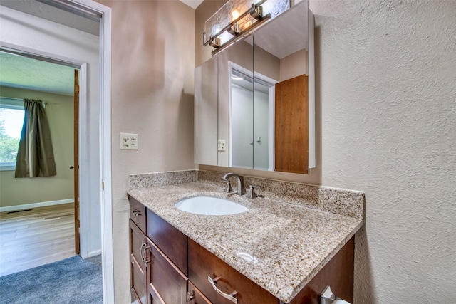 229 Glacier Dr, Lolo, MT 59847 - bathroom featuring a textured wall, vanity, and baseboards